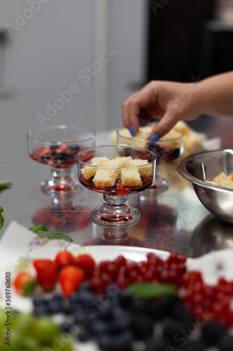 The pastry chef prepares a trifle in the kitchen