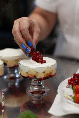 Confectioner decorates dessert with berries