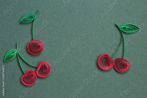 Beautiful Ripe cherries designs isolated on green paper background. Paper quilling of cherry - fresh fruit, natural berry. Berries with stems and green leaves. Hand made of paper quilling technique