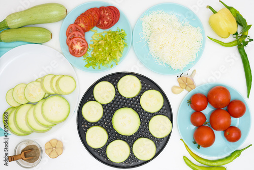 step by step recipe and ingredients for cooking homemade zucchini mini portioned pizza with mozzarella and tomatoes, pepper and garlic. top view on a light background.
