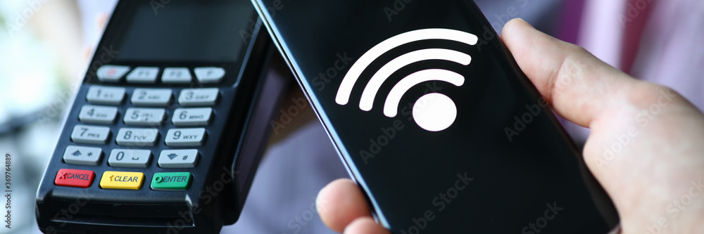 People hold portable terminal and smartphone. Payment by contactless means during quarantine. Non-contact payment method supported by electronic devices. Hand bring phone to terminal People hold portable terminal and smartphone. Payment by contactless means during quarantine. Non-contact payment method supported by electronic devices. Hand bring phone to terminal