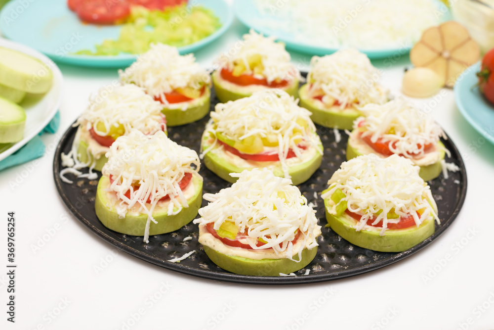 step by step recipe and ingredients for cooking homemade zucchini mini portioned pizza with mozzarella and tomatoes, pepper and garlic. top view on a light background. step by step recipe and ingredients for cooking homemade zucchini mini portioned pizza with mozzarella and tomatoes, pepper and garlic. top view on a light background.