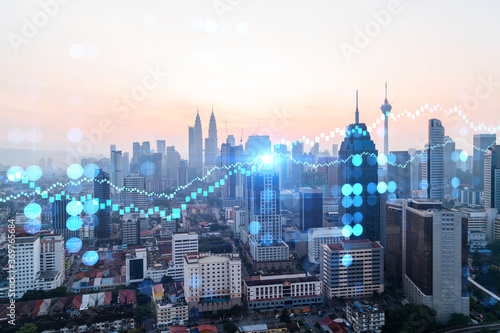 Glowing FOREX graph hologram  aerial panoramic cityscape of Kuala Lumpur at sunset. Stock and bond trading in KL  Malaysia  Asia. The concept of fund management. Double exposure.