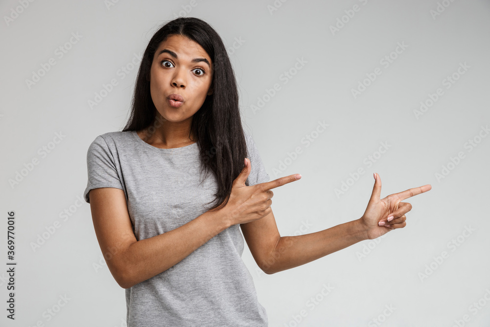 Smiling young african woman pointing at copy space Smiling young african woman pointing at copy space