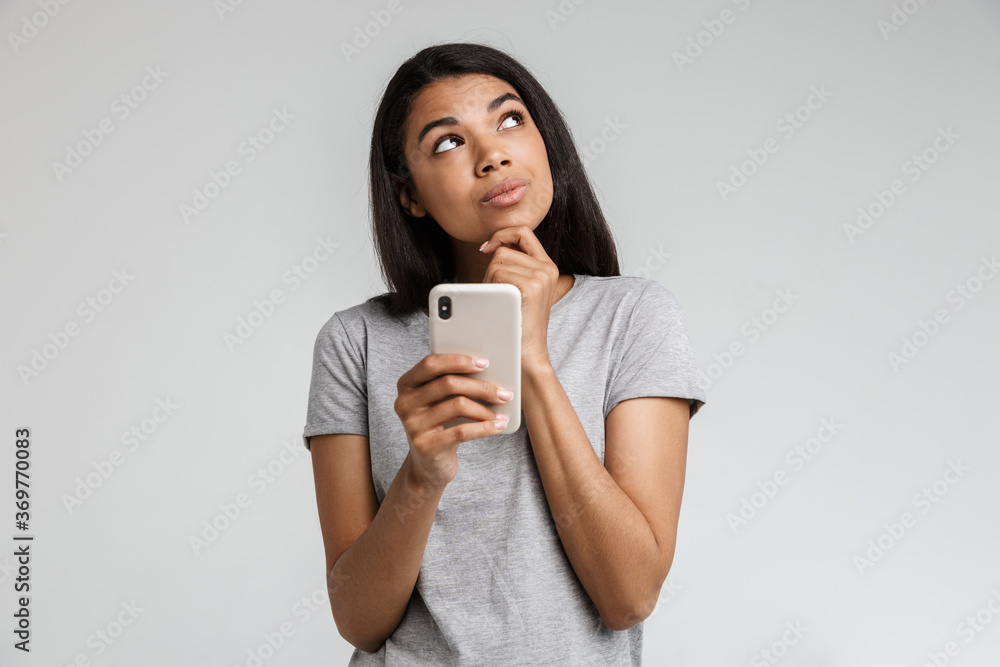 Smiling young african woman texting on mobile phone Smiling young african woman texting on mobile phone