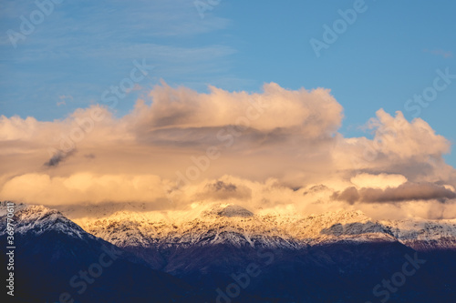 Amazing clouds and blue sky over The Andes Mountains with a golden sunlight, Chile