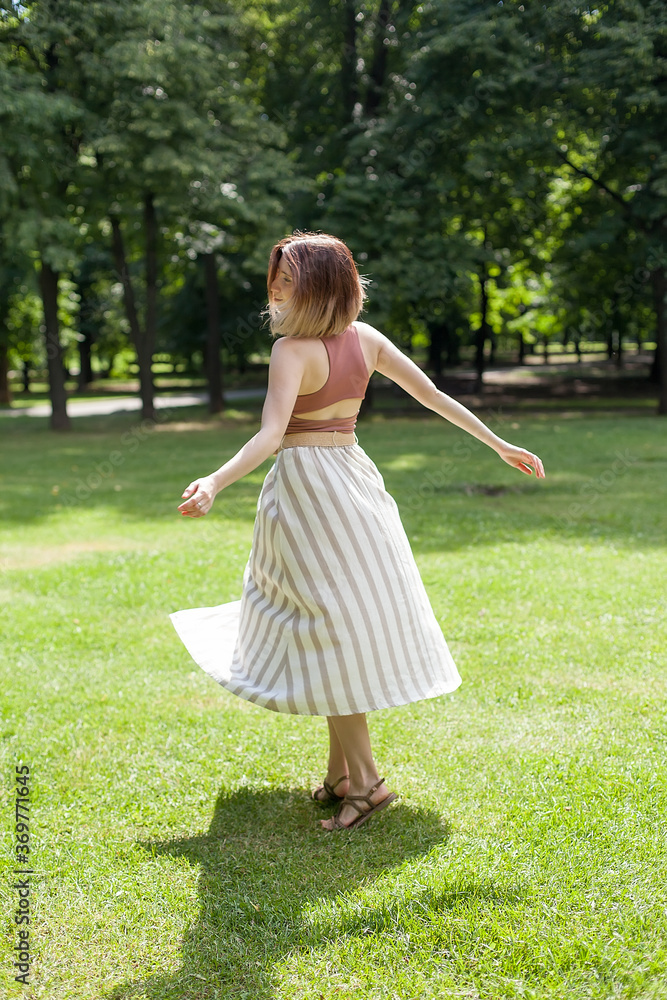 beautiful girl laughs and dances outdoors in a meadow during sunset beautiful girl laughs and dances outdoors in a meadow during sunset