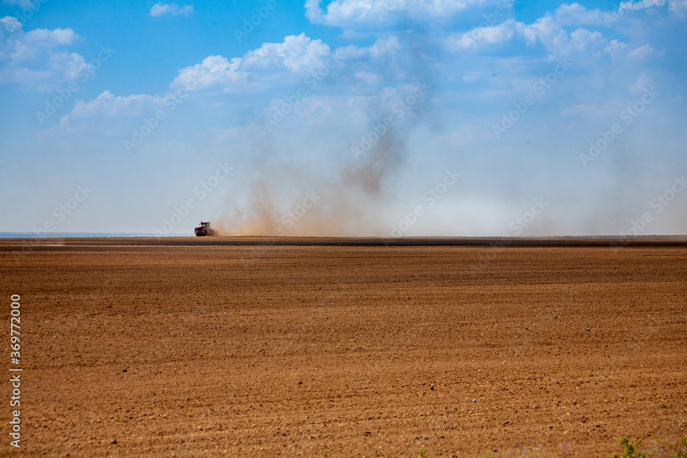 Obraz premium Tractor plowing the fields in spring