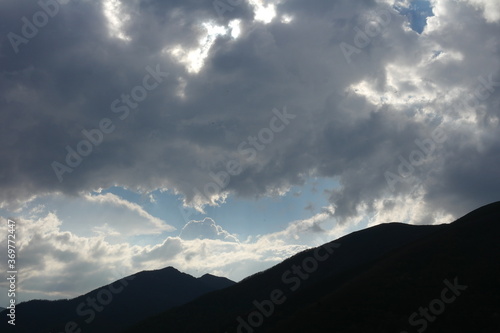 Wooded mountains illuminated by sunlight creating a beautiful atmosphere, with a very bright sky. Muniellos National Reserve, Asturias, Spain.