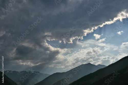 Wooded mountains illuminated by sunlight creating a beautiful atmosphere, with a very bright sky. Muniellos National Reserve, Asturias, Spain.