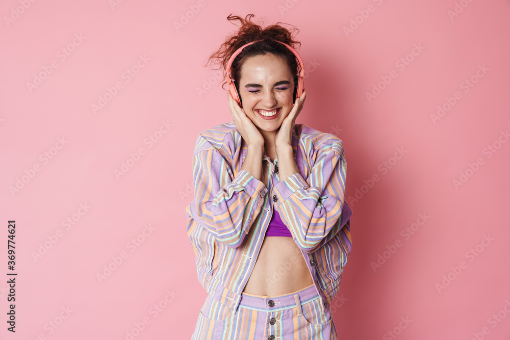 Obraz premium Image of ginger excited woman laughing while using wireless headphones