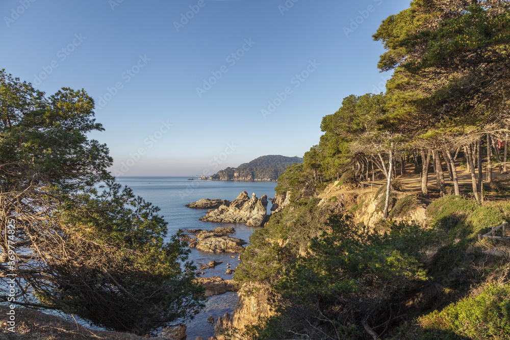 View of the picturesque bay with green pine trees. Azure water and hidden beaches. Blanes. Costa Brava. Catalonia. Spain. View of the picturesque bay with green pine trees. Azure water and hidden beaches. Blanes. Costa Brava. Catalonia. Spain.