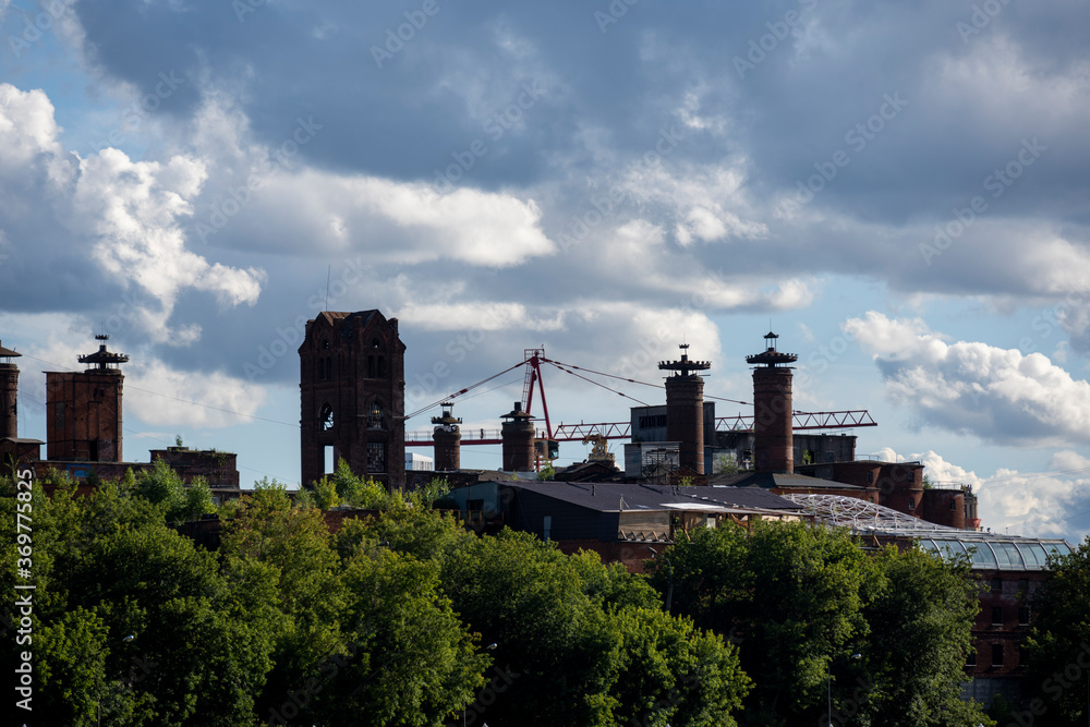 old red brick factory as a medieval fortress against a blue sky with clouds