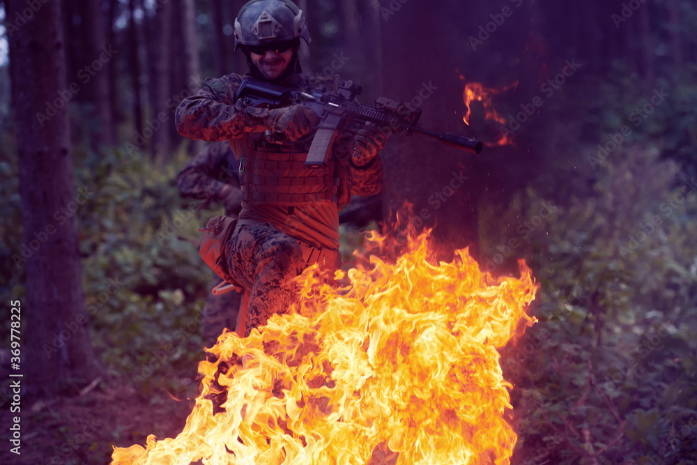 Soldier in Action at Night jumping over fire Soldier in Action at Night jumping over fire