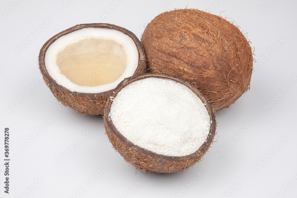 coconut halves with coconut, milk and pulp on a white background