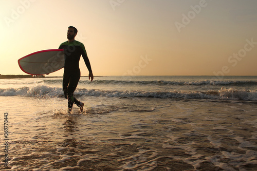 Surfer getting out of the water © ATARES Design