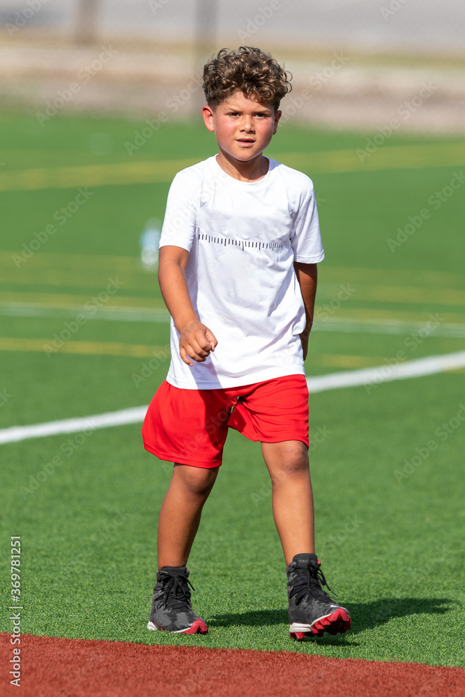 Cute athletic little boy playing excitedly in a flag football game Cute athletic little boy playing excitedly in a flag football game
