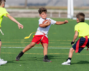 Cute athletic little boy playing excitedly in a flag football game