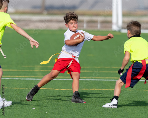Cute athletic little boy playing excitedly in a flag football game
