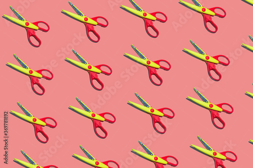 Open plastic yellow and red scissors on pastel pink color background. Seamless colorful pattern.