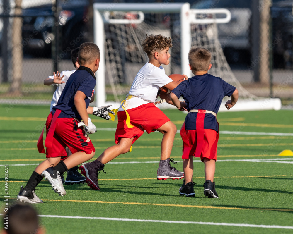 Cute athletic little boy playing excitedly in a flag football game Cute athletic little boy playing excitedly in a flag football game