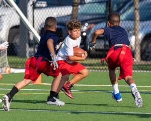 Cute athletic little boy playing excitedly in a flag football game
