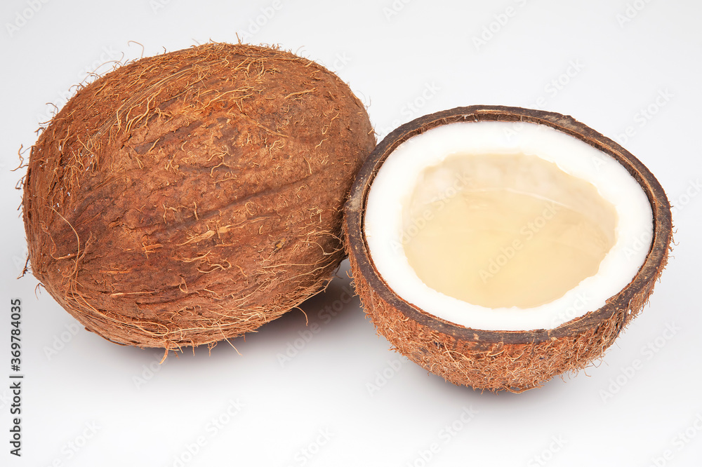 coconut halves with coconut, milk and pulp on a white background coconut halves with coconut, milk and pulp on a white background