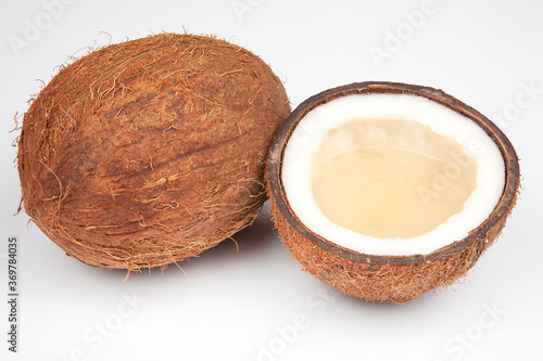 coconut halves with coconut, milk and pulp on a white background