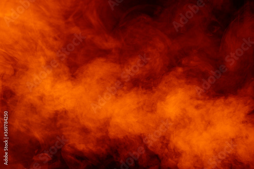 Orange smoke on black background photo