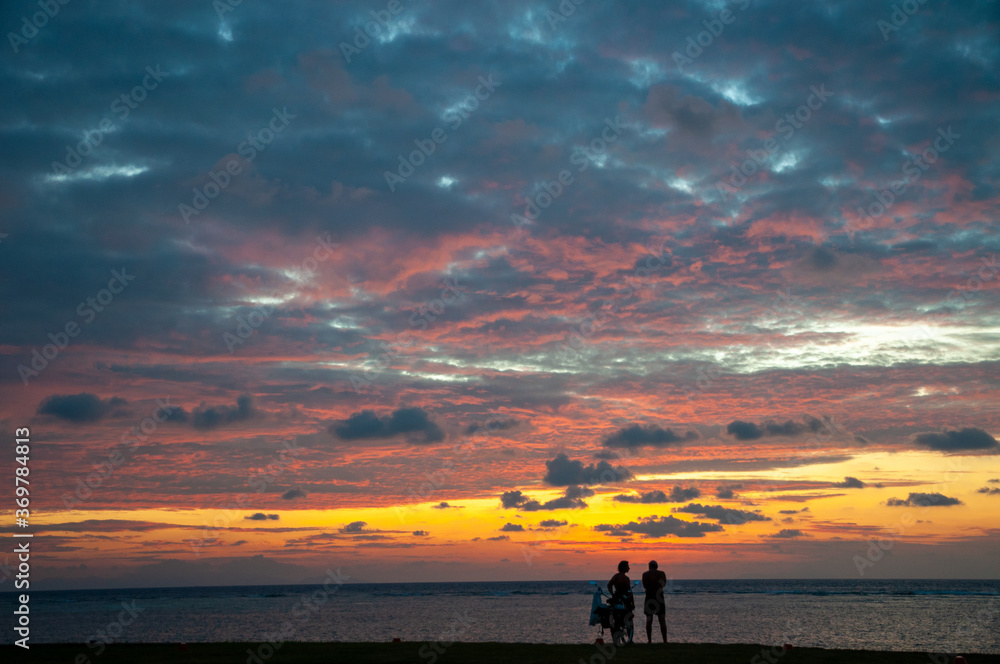 Beautiful scenic tropical view sunset over the ocean horizon with black silhouette of a people on the waterfront. Beautiful scenic tropical view sunset over the ocean horizon with black silhouette of a people on the waterfront.