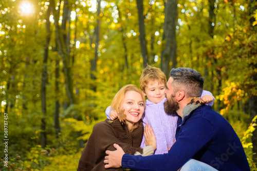 Happy family in autumn park. Autumn Family. Family parenthood and people concept - happy mother father and little boy in autumn park. Happy family together in yellow nature. © Svitlana