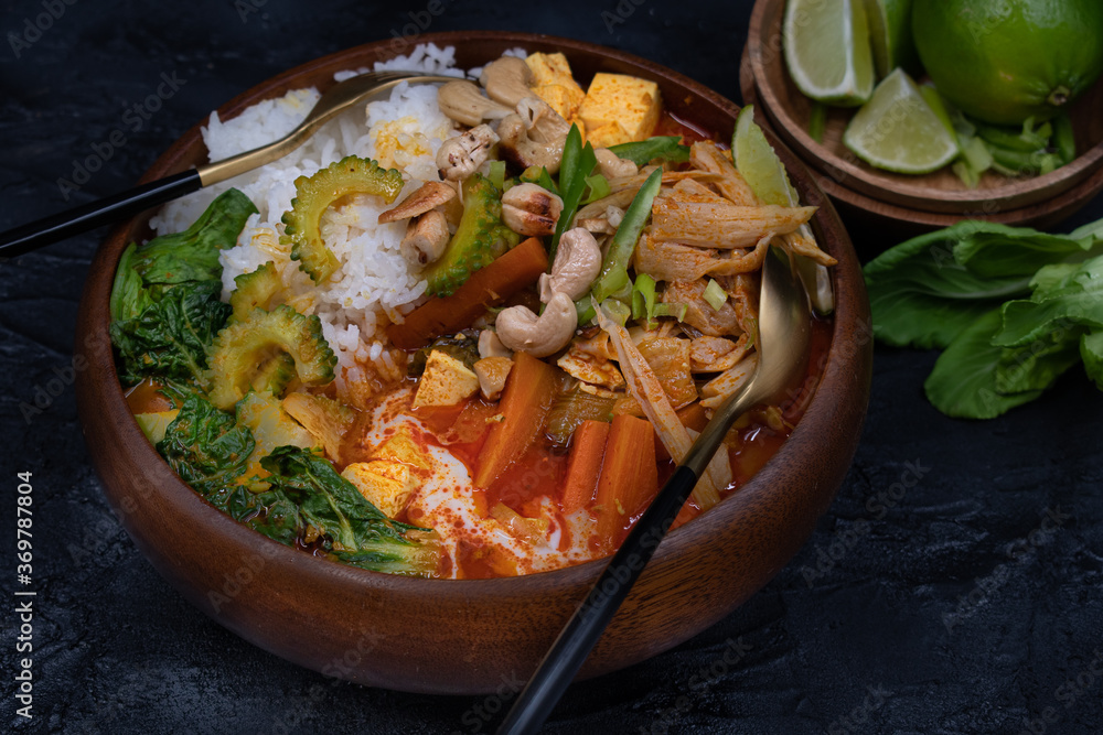 Vegan thai red curry with king oyster mushrooms, carrot, tofu, bokchoy, bitter gourd, cashew nuts. Jasmine rice. Copy space. Vegan thai red curry with king oyster mushrooms, carrot, tofu, bokchoy, bitter gourd, cashew nuts. Jasmine rice. Copy space.