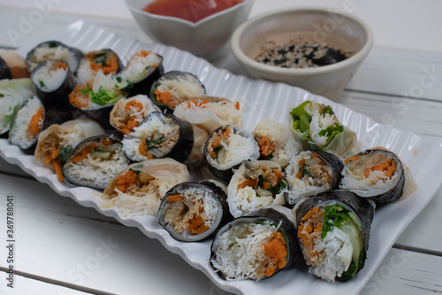 Vegan Vietnamese spring rolls on white platter, chili and soy sauce