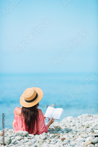 Obraz na płótnie Young woman reading book during tropical white beach w salonie