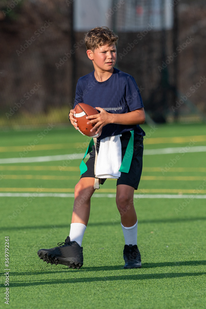 Obraz premium Young athletic boy playing in a flag football game