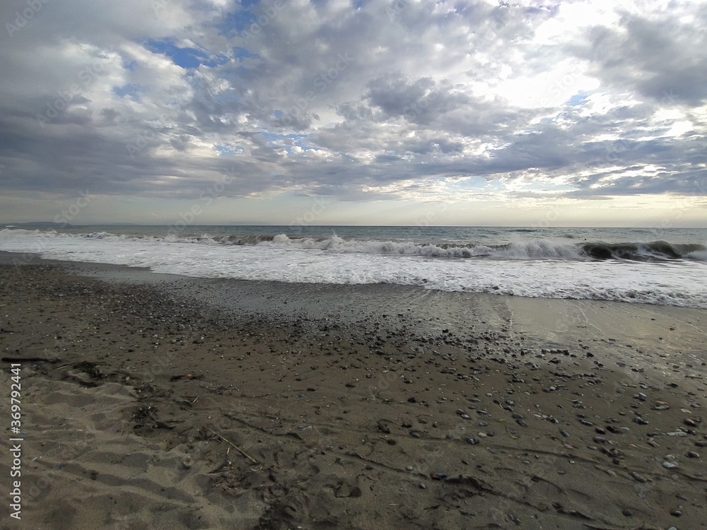 Beach at sunset. Sea in Marina di Bibbona at sunset, evening sky with clouds, Italy. Mediterranean Sea, beautiful sandy beach, waves. Beach at sunset. Sea in Marina di Bibbona at sunset, evening sky with clouds, Italy. Mediterranean Sea, beautiful sandy beach, waves.