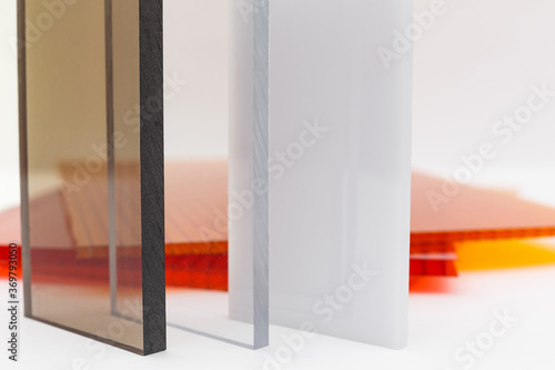 Solid Polycarbonate Sheet. Brown and transparent. Acrylic Plastic glass. Colored pc sheet on background