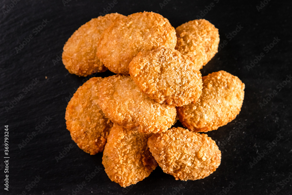 Chicken fried nuggets on a dark background. Fast food concept Chicken fried nuggets on a dark background. Fast food concept