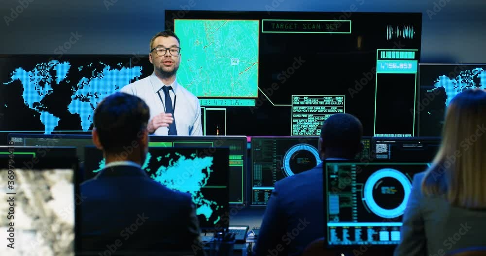 Caucasian man professional army analytic talking at maps and screens with geolocations, explaining cybersecurity to mixed-races people. Multiethnic military workers listening to male security speaker. Caucasian man professional army analytic talking at maps and screens with geolocations, explaining cybersecurity to mixed-races people. Multiethnic military workers listening to male security speaker.