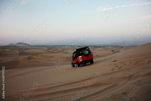 A buggie that is riding over the sand dunes in the desert nearby Ica in Peru with tourists © pangamedia