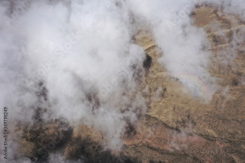 Bird eye view of clouds that are running over a desert landscape