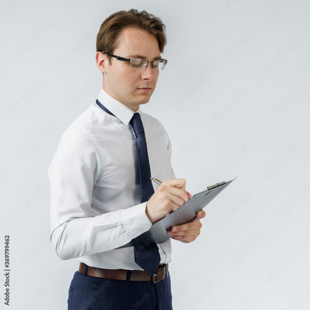 Portrait of a businessman who stands and writes down on a tablet. White background. Portrait of a businessman who stands and writes down on a tablet. White background.