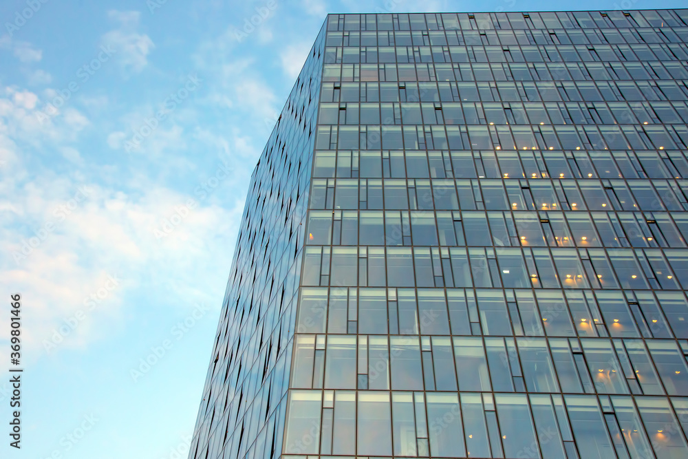 Glass facade of a modern multi-storey building against the sky Glass facade of a modern multi-storey building against the sky