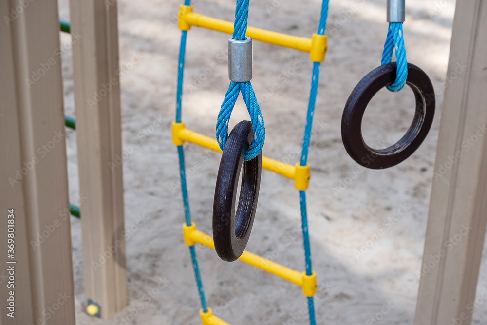 Children's exercise outdoors, rope ladder, rings. Sport and physical development of children.