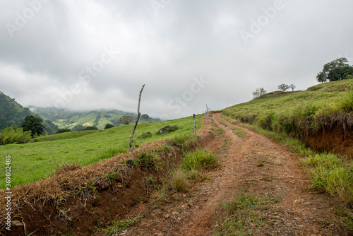 Path with grass and trees with cloudy sky. Tamesis, Antioquia, Colombia.  photo