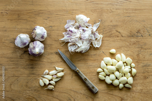 Garlic and a knife on a cutting board.