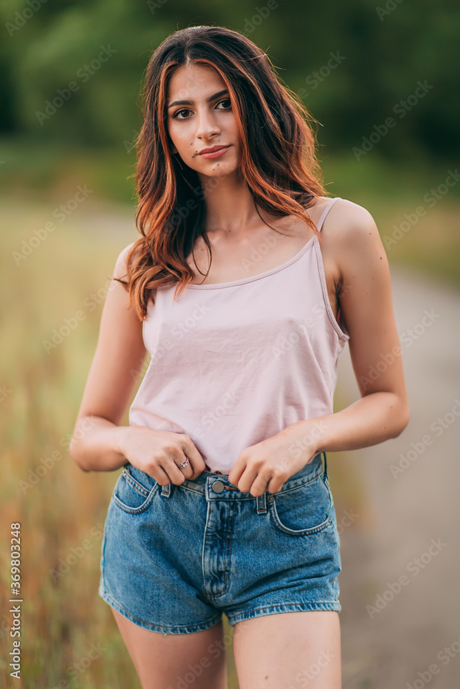 Portrait of young attractive woman wearing tank top and shorts