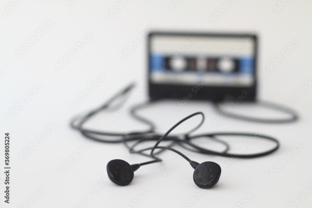 Blue -White audio cassette and cassette pleer with headphones on a white background. Party 90s concept Blue -White audio cassette and cassette pleer with headphones on a white background. Party 90s concept