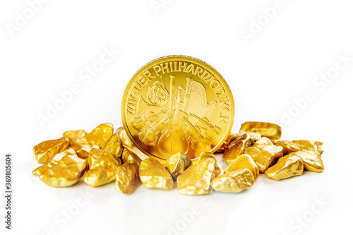 golden austrian philharmoniker one ounce coin laying on a heap of golden nuggets, golden ore