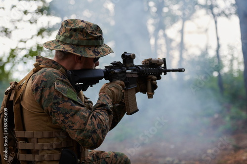 soldier in action aiming on weapon laser sight optics